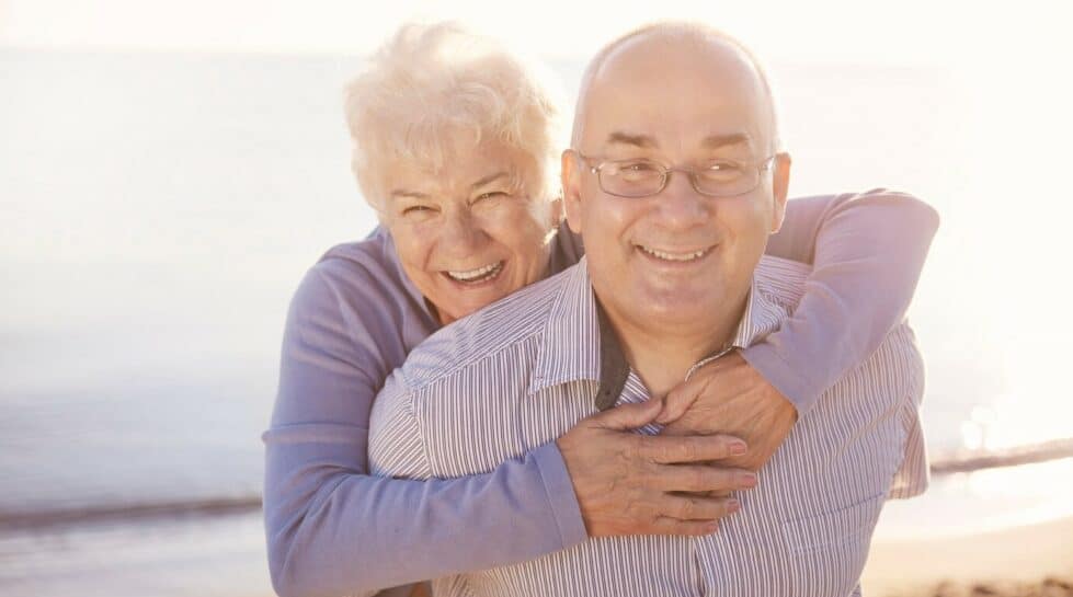 couple de seniors heureux qui se font un câlin sur la plage