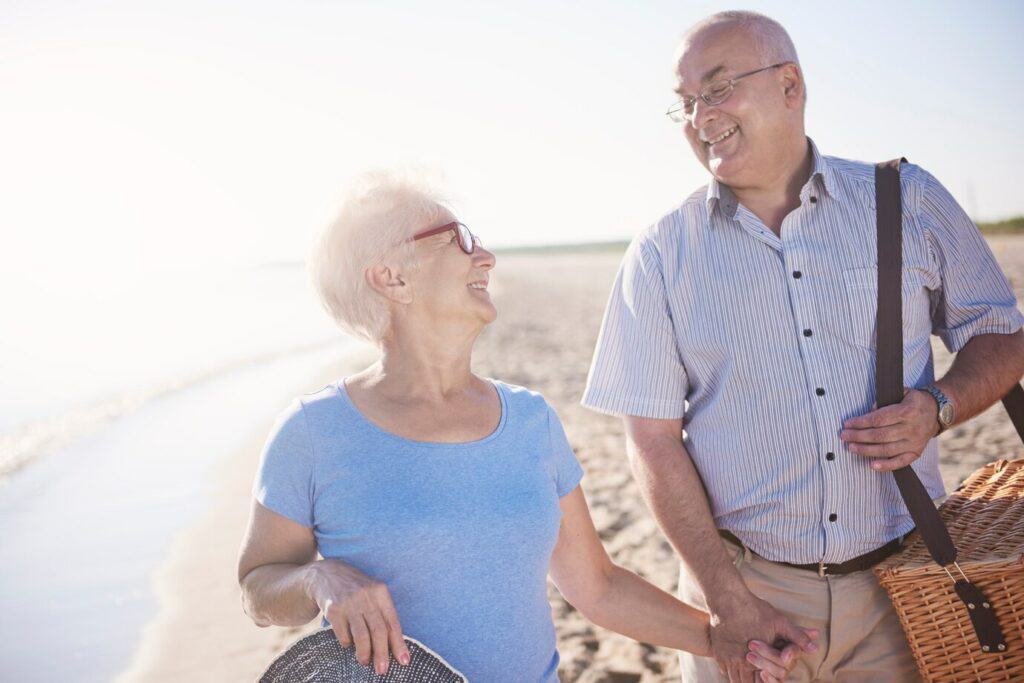 seniors heureux se regardant au bord de la plage