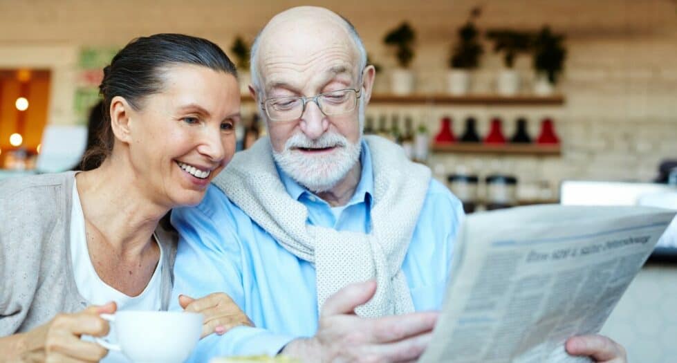 seniors heureux en train de lire le journal et de boire un café