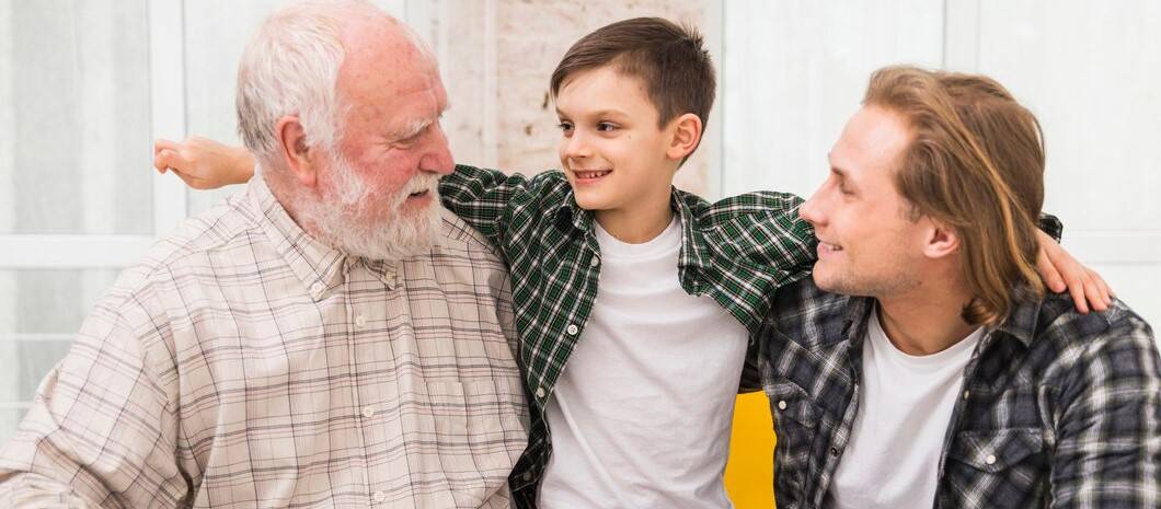 photo de famille avec 3 générations : le fils, le père et le grand-père, tous les trois avec une chemise à carreaux